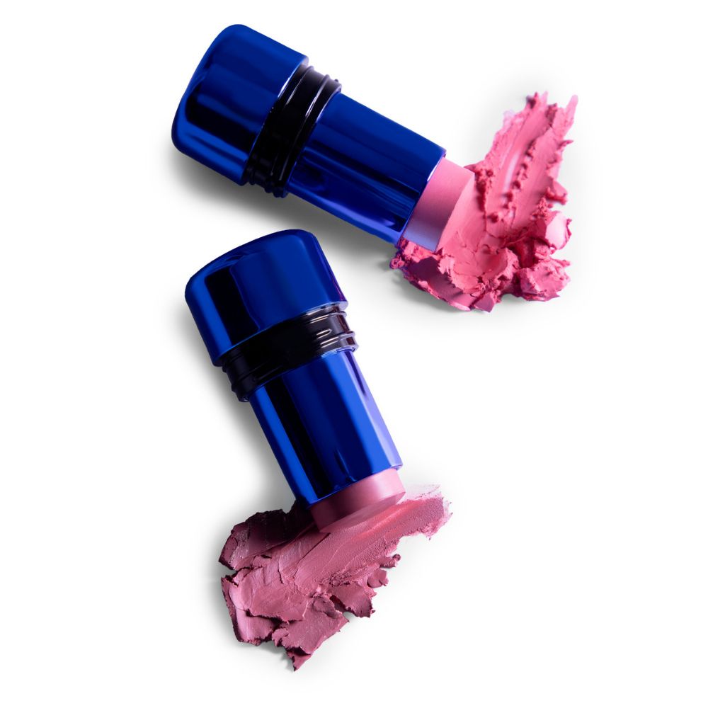 Due contenitori blu con rossetto e fard rosa. Il prodotto è visibile.