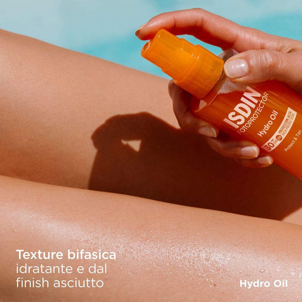 Gamba con ISDIN Hydro Oil. Texture bifasica, idratante e finish asciutto. Flacone sullo sfondo.
