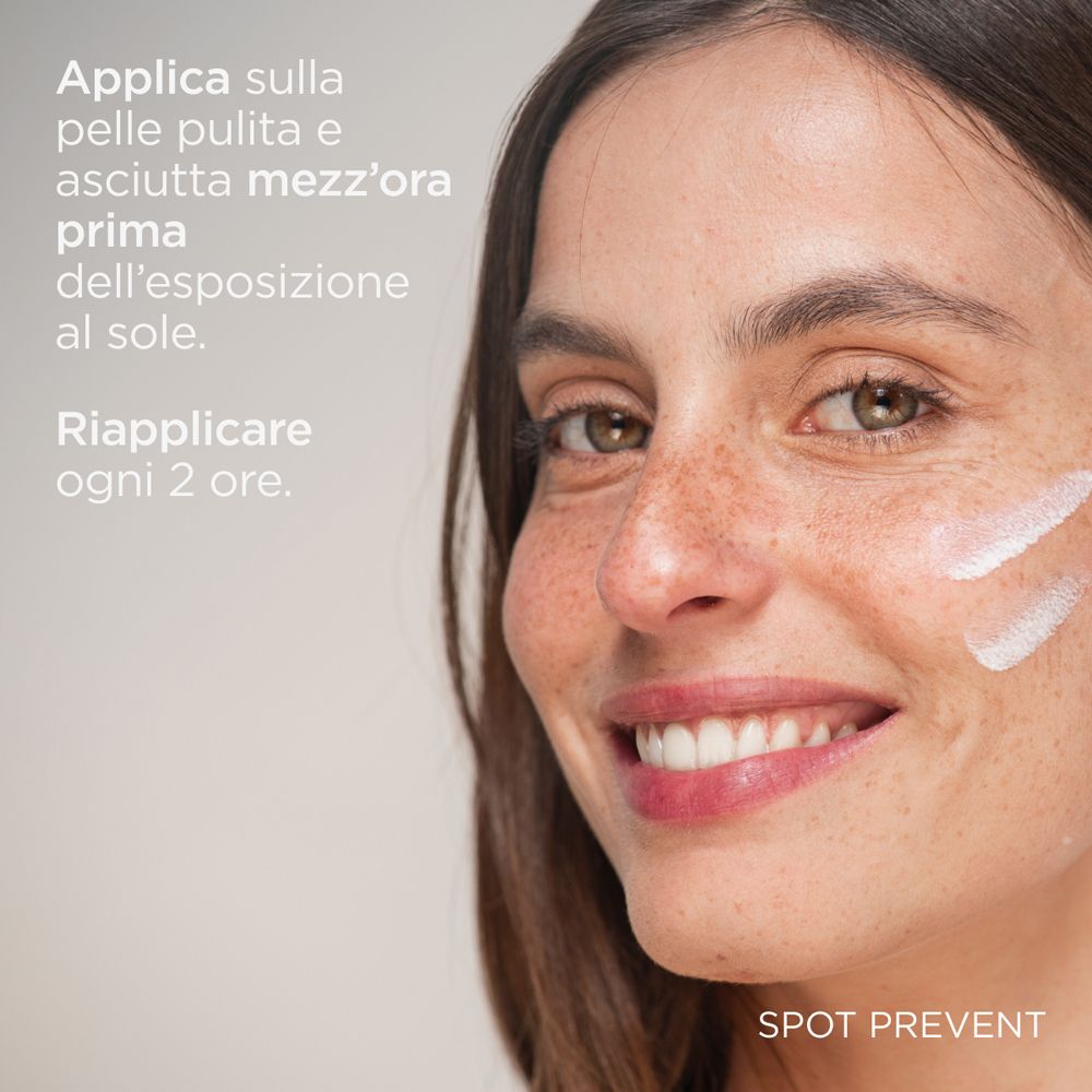 Primo piano di un viso. Due strisce bianche sulla pelle. Testo: « Applicare sulla pelle pulita e asciutta mezz'ora prima dell'esposizione al sole ».