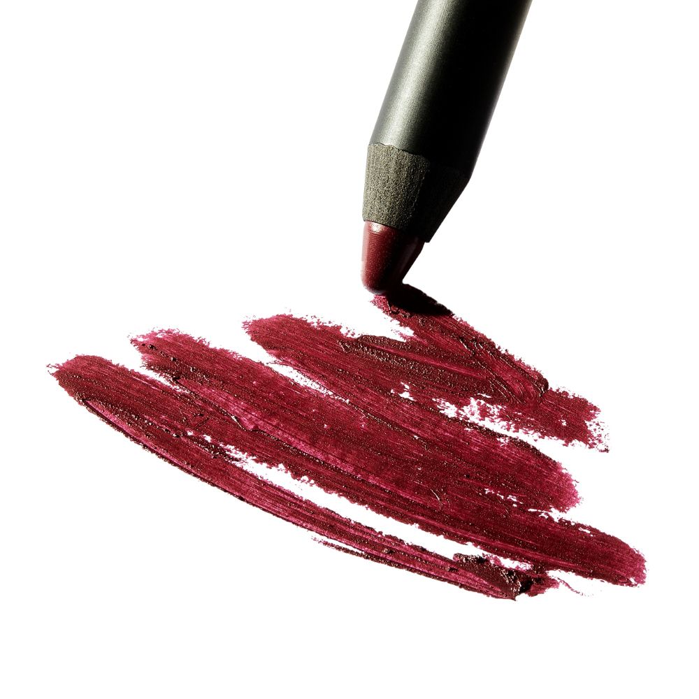 Matita labbra traccia linee. Rossetto bordeaux su sfondo bianco. Trama visibile.
