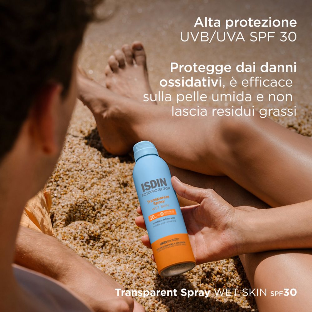Persona che tiene un flacone spray blu. ISDIN Fotoprotector Transparent Spray Wet Skin SPF30. Testo: Alta protezione, efficace sulla pelle bagnata.