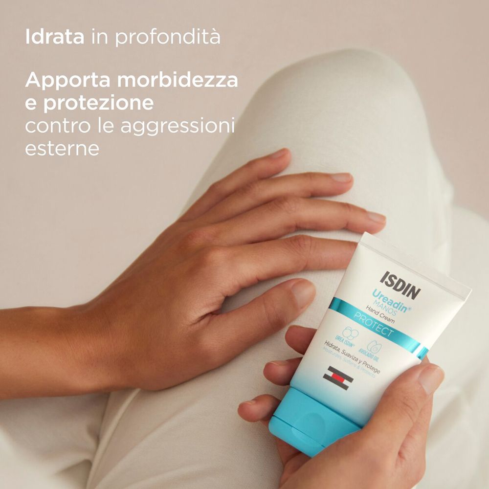 Mani che tengono un tubetto di crema. Scritta: ISDIN Ureadin MANOS Hand Cream. Strisce blu e rosse.