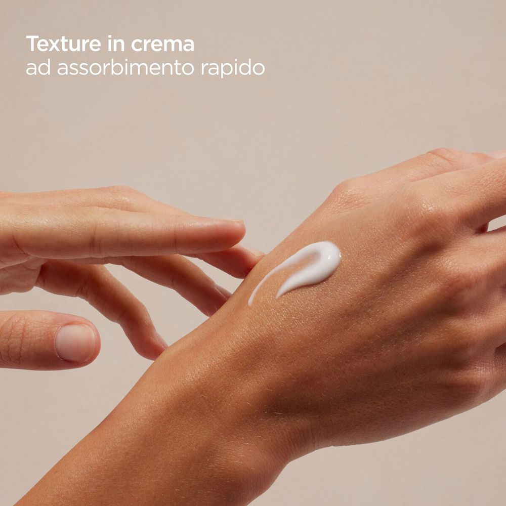 Mano con crema. Scritta: ISDIN Ureadin MANOS Hand Cream. Strisce blu e rosse.