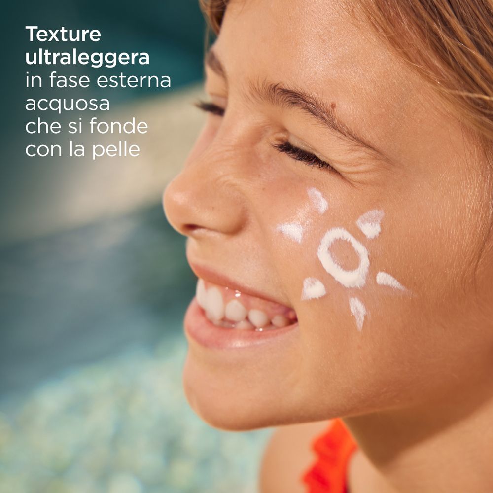 Ragazza con simbolo solare di crema solare sulla guancia. Testo: Texture ultraleggera in fase esterna acquosa che si fonde con la pelle.