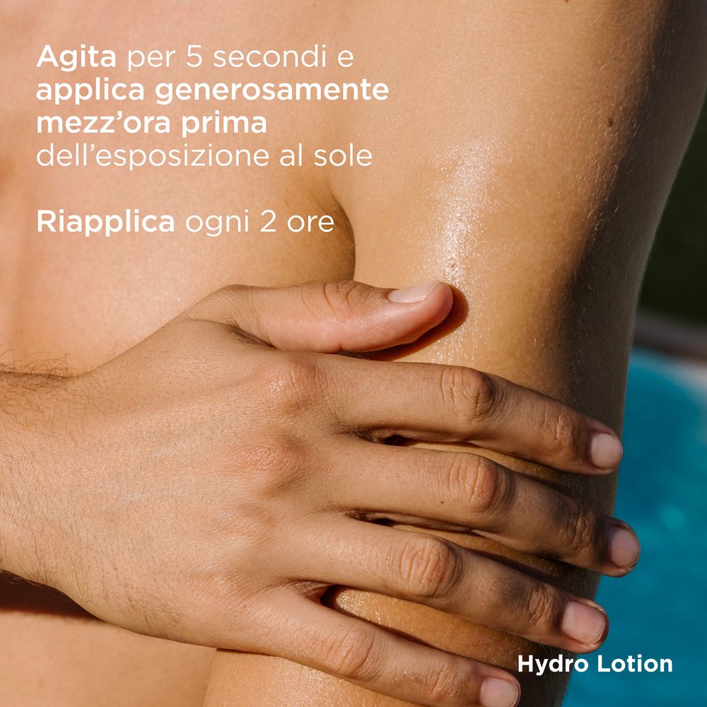 Mano che applica ISDIN Hydro Lotion sul braccio. Testo: Agita per 5 secondi e applica generosamente mezz'ora prima dell'esposizione al sole.