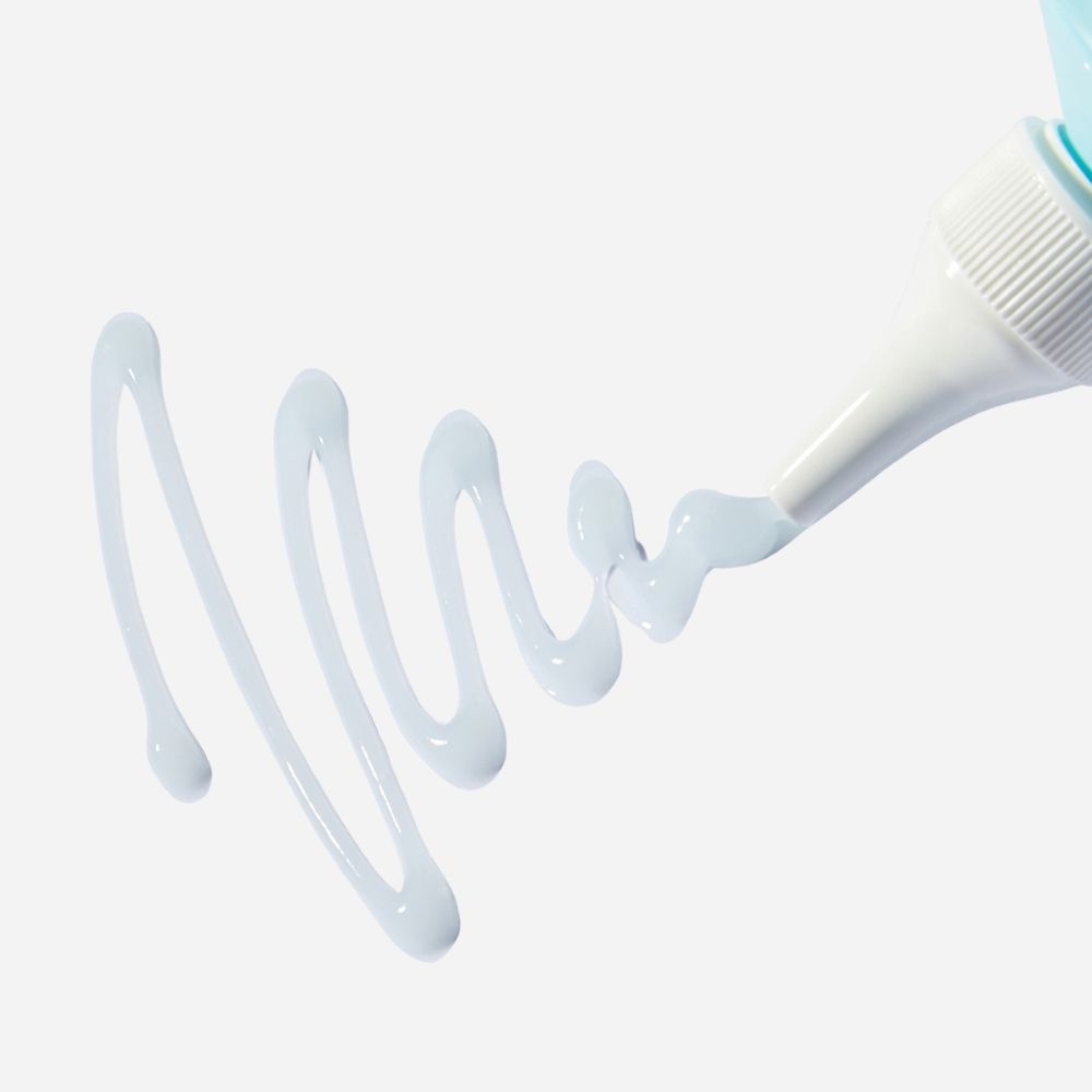 Primo piano di un prodotto che esce da un tubo. Liquido azzurro.