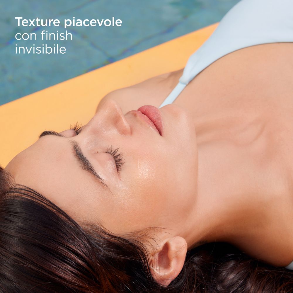 Primo piano di un viso. Testo: Texture piacevole con finish invisibile. Persona sdraiata su tappetino giallo.