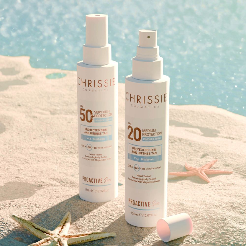 Due spray Chrissie Cosmetics, SPF 50+ e SPF 20, sulla spiaggia. Stelle marine sulla sabbia.