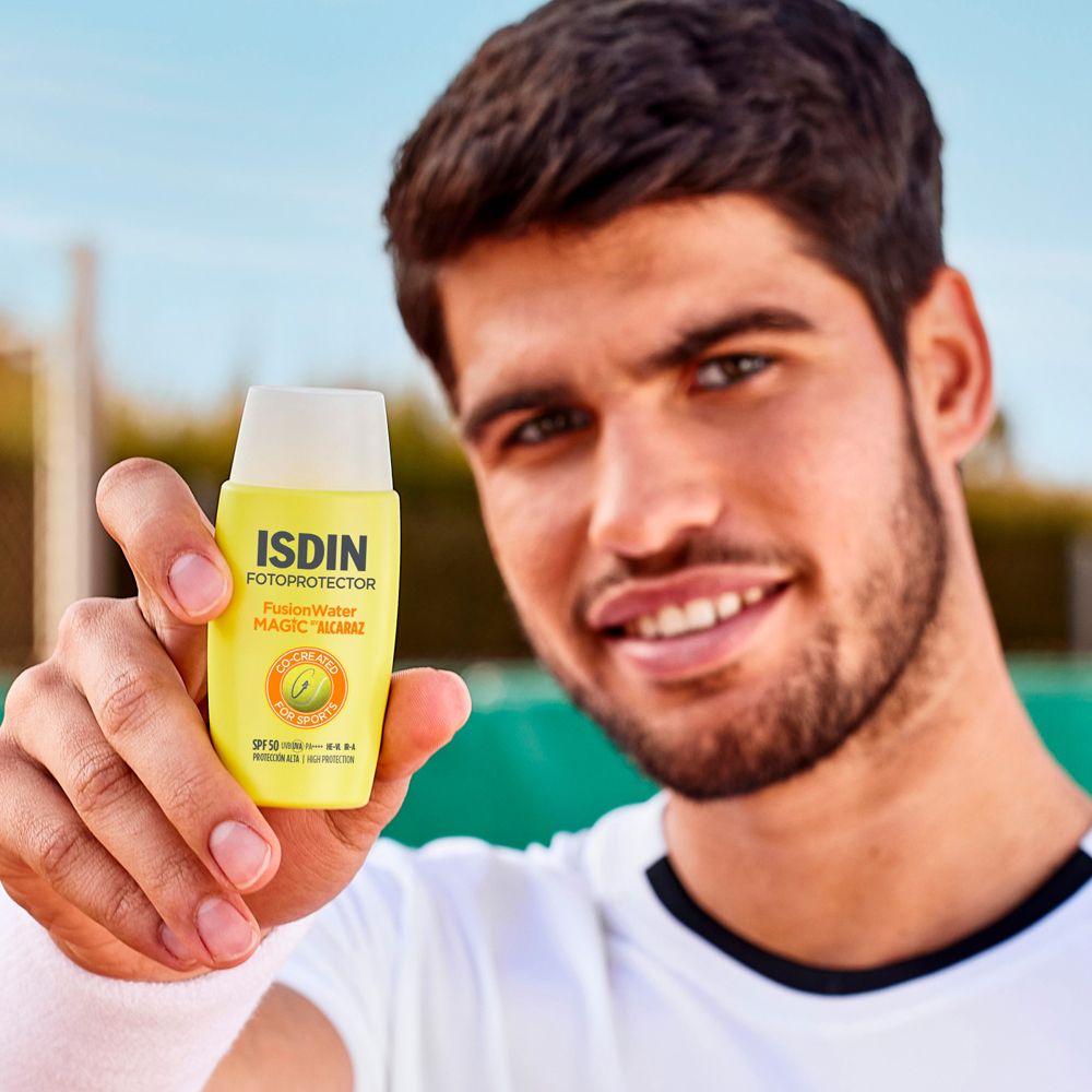 Uomo con crema solare. ISDIN Fotoprotector Fusion Water Magic. Campo da tennis sullo sfondo.