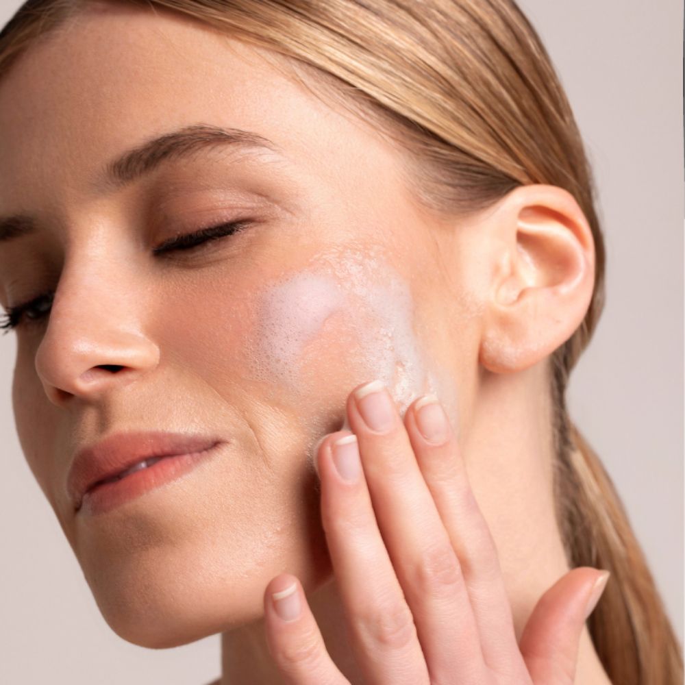 Donna applica maschera sul viso. Prodotto sulla pelle.