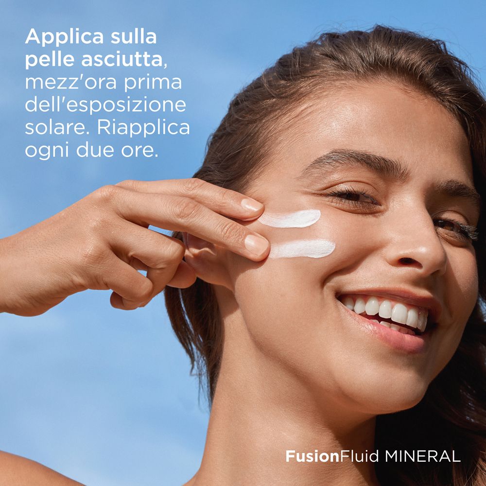 Donna applica crema solare sul viso. Testo: Applica sulla pelle asciutta, mezz'ora prima dell'esposizione solare. Riaplica ogni due ore.