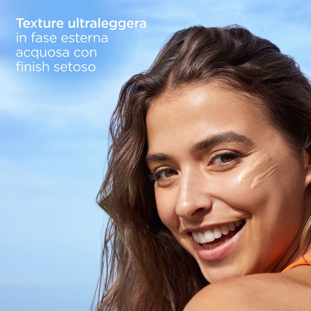 Primo piano di una donna con crema solare sulla pelle. Testo: Texture ultraleggera in fase esterna acquosa.