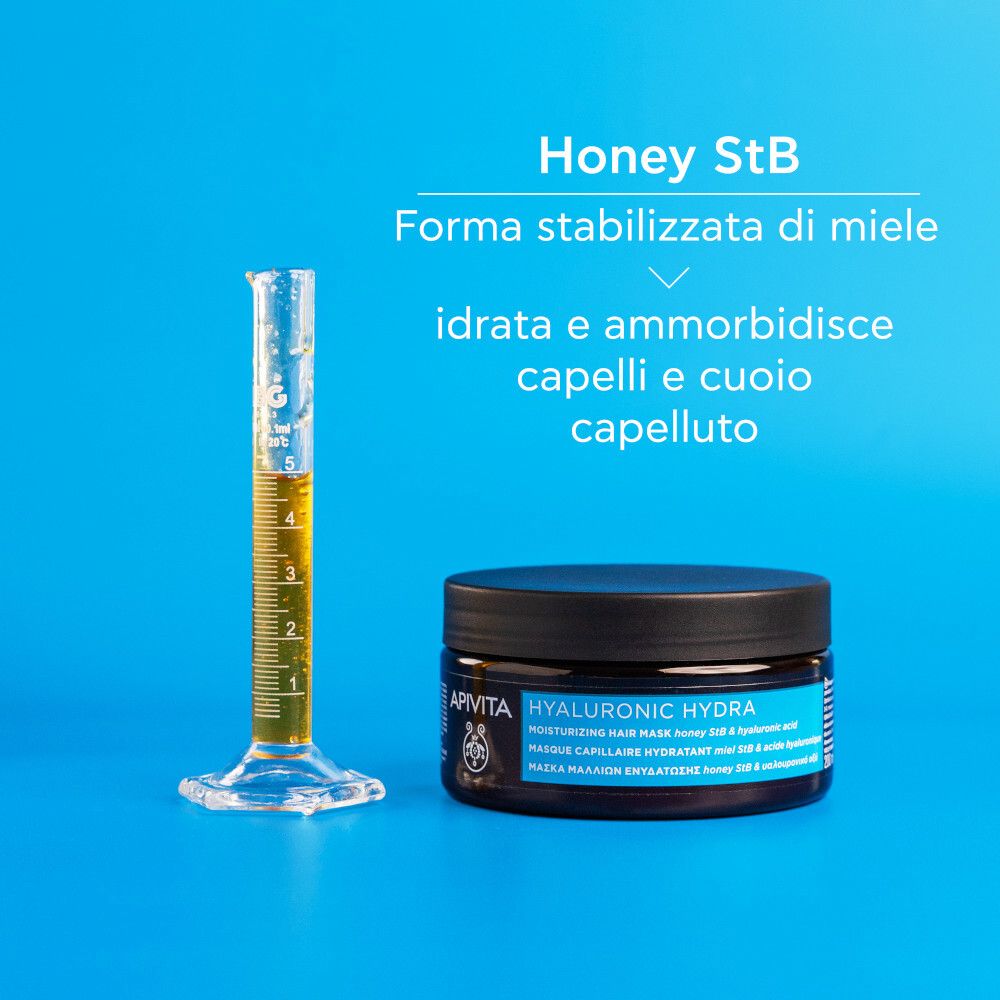 Contenitore con liquido giallo accanto al barattolo. Scritta: APIVITA, HYALURONIC HYDRA. Testo: Miele StB, forma di miele stabilizzata.