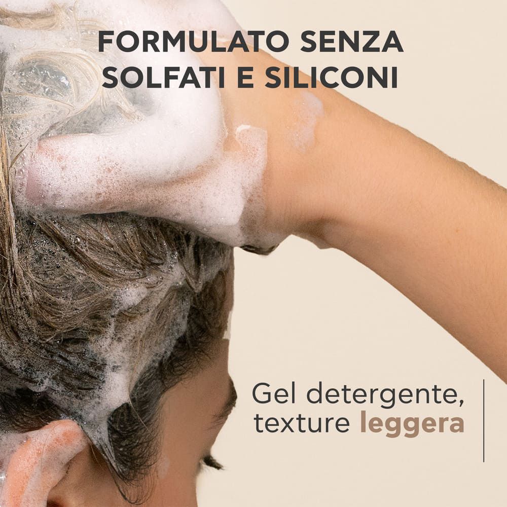Mani che lavano i capelli con schiuma. Testo: Formula senza solfati e siliconi. Gel detergente.