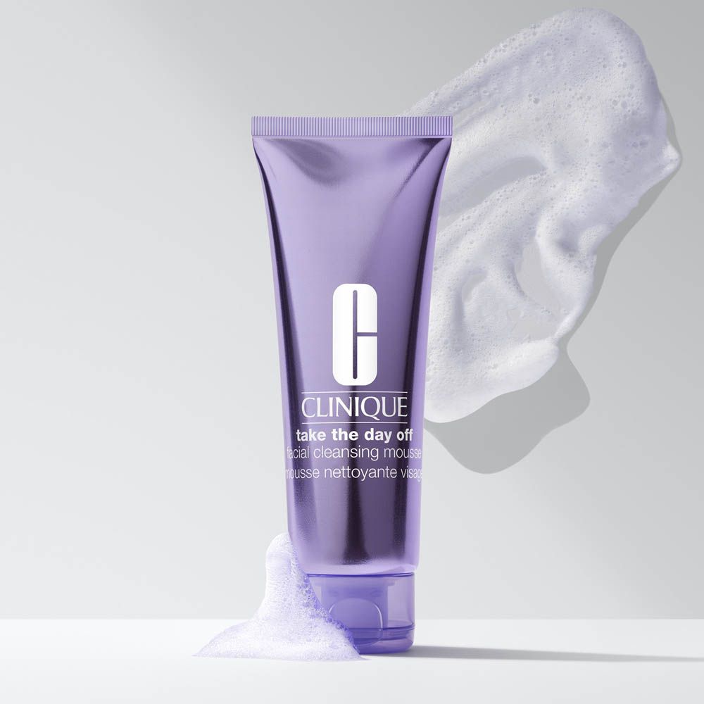 Mousse detergente viso Clinique in un tubetto viola con schiuma.