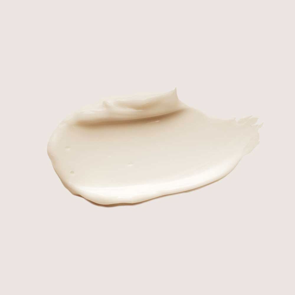 Macchia di una sostanza color crema su sfondo rosa. Consistenza visibile.