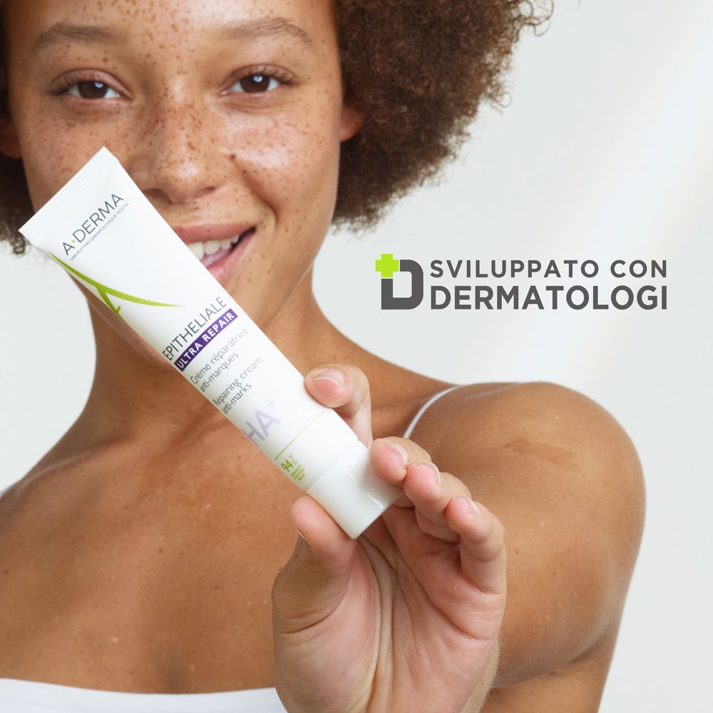 Donna che tiene un tubo di crema. Testo: Sviluppato con dermatologi. Logo: A-DERMA Epitheliale Ultra Repair.