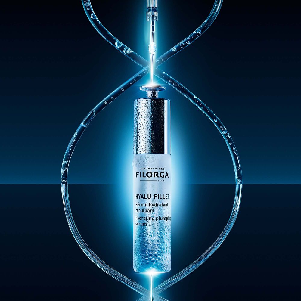 Siero Filorga Hyalu-Filler. Flacone circondato da linee blu luminose. Testo: Hyalu-Filler, Sérum hydratant repulpant.