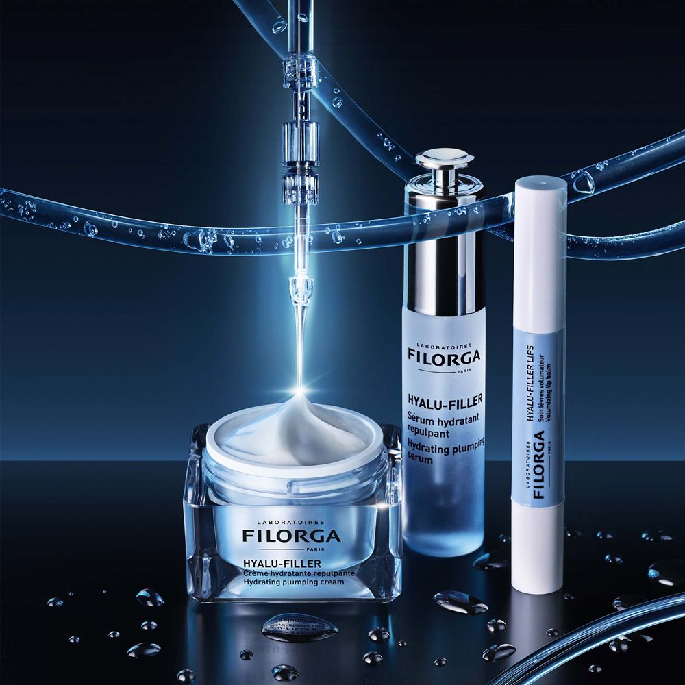 Prodotti Filorga. Crema, siero e balsamo labbra. Confezione blu e argento. Gocce d'acqua.