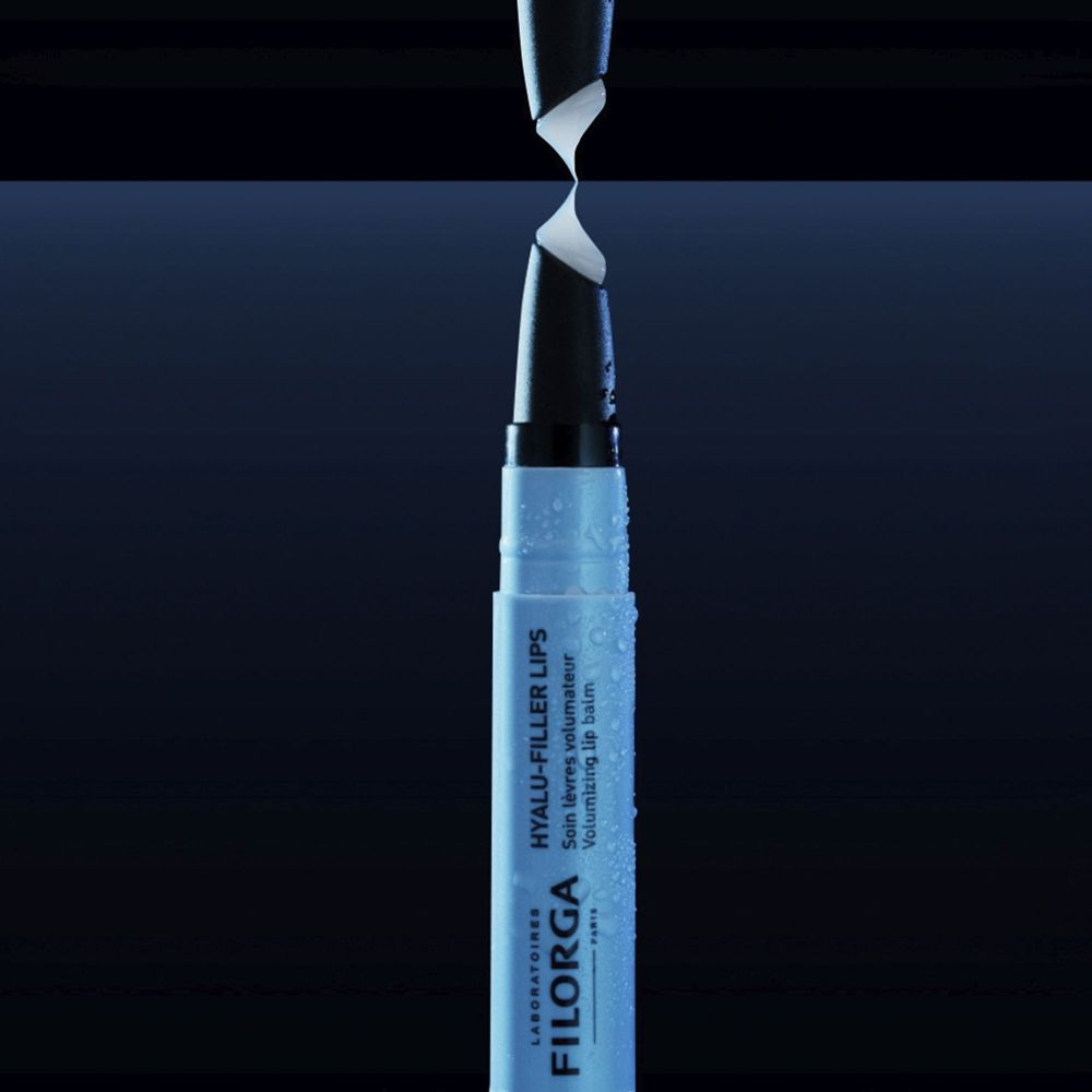 Stick balsamo labbra con applicatore nero. Scritta: HYALU-FILLER LIPS, FILORGA. Gocce.