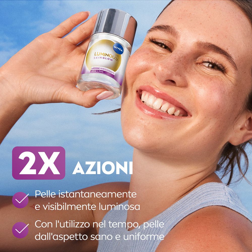Donna tiene in mano il flacone del prodotto. 2 azioni. Pelle istantaneamente e visibilmente luminosa. Pelle sana e uniforme.
