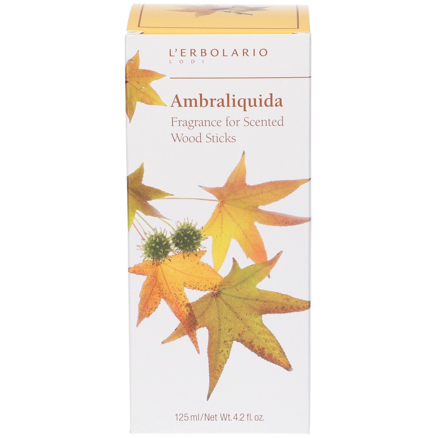 Scatola con nome del prodotto e foglie. Testo: Ambraliquida Fragrance for Scented Wood Sticks. 125 ml/Net Wt. 4.2 fl. oz.