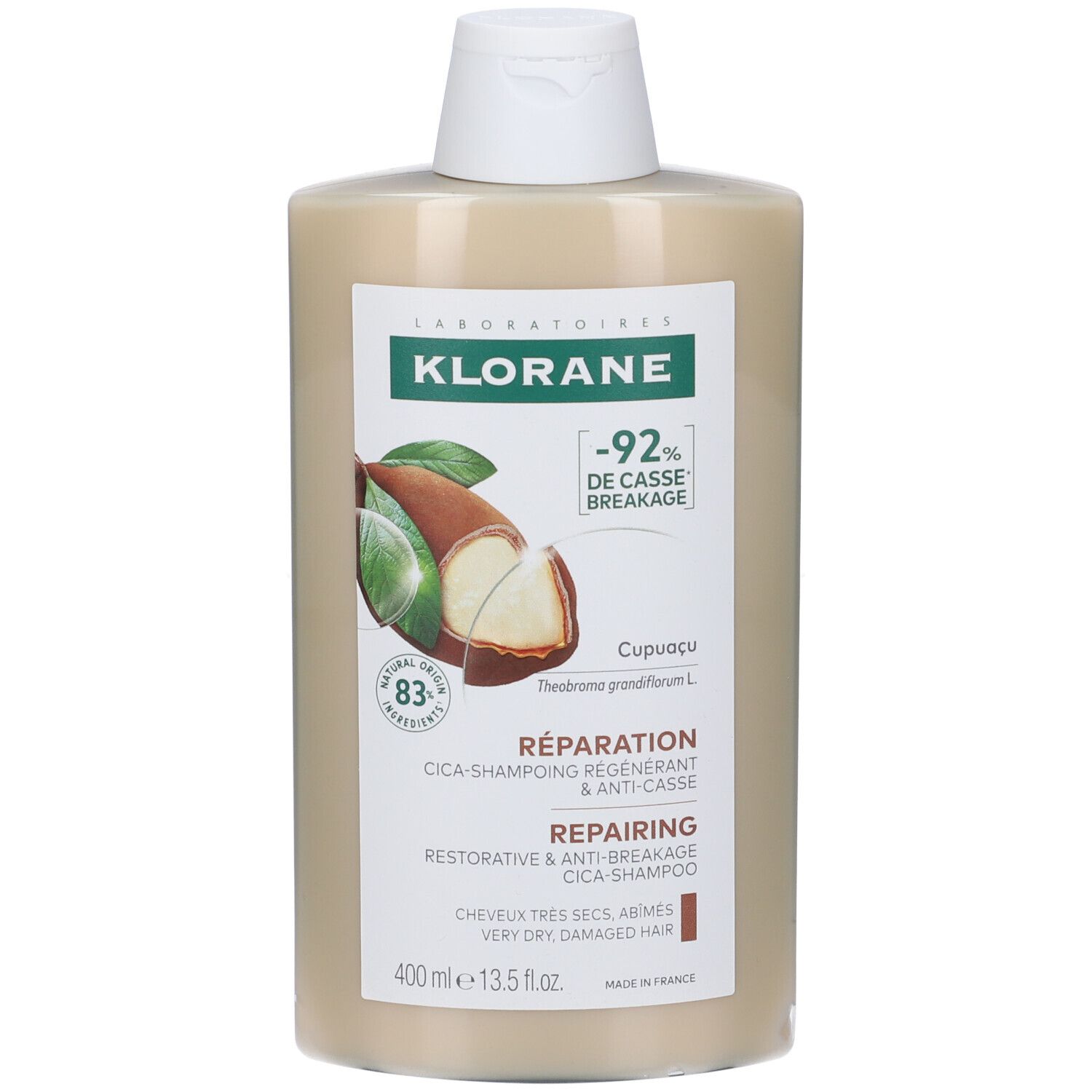 Flacone di shampoo riparatore Klorane. Beige con tappo bianco. Etichetta con informazioni e logo. 400 ml.