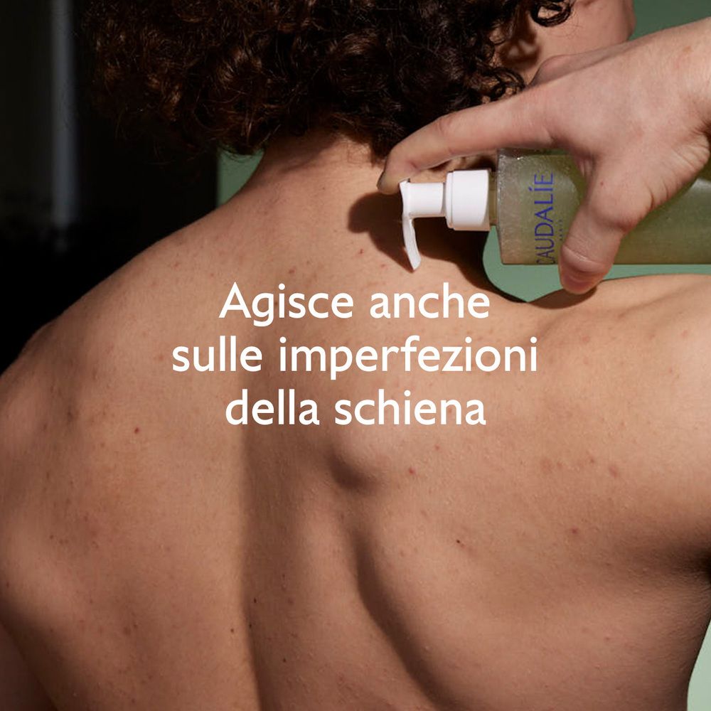 Schiena con brufoli. Persona tiene una bottiglia. Testo: Agisce anche sulle imperfezioni della schiena.