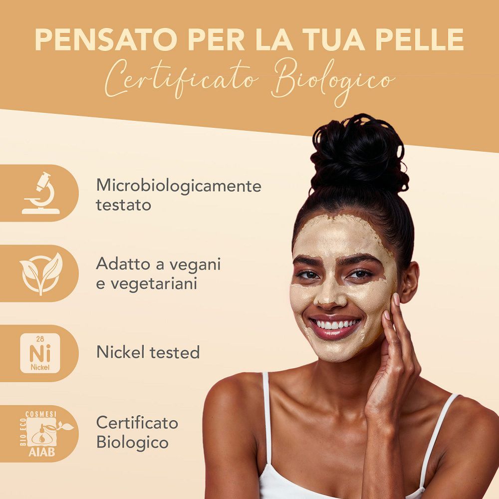 Donna con maschera all'argilla dorata sul viso. Testato microbiologicamente, vegano.