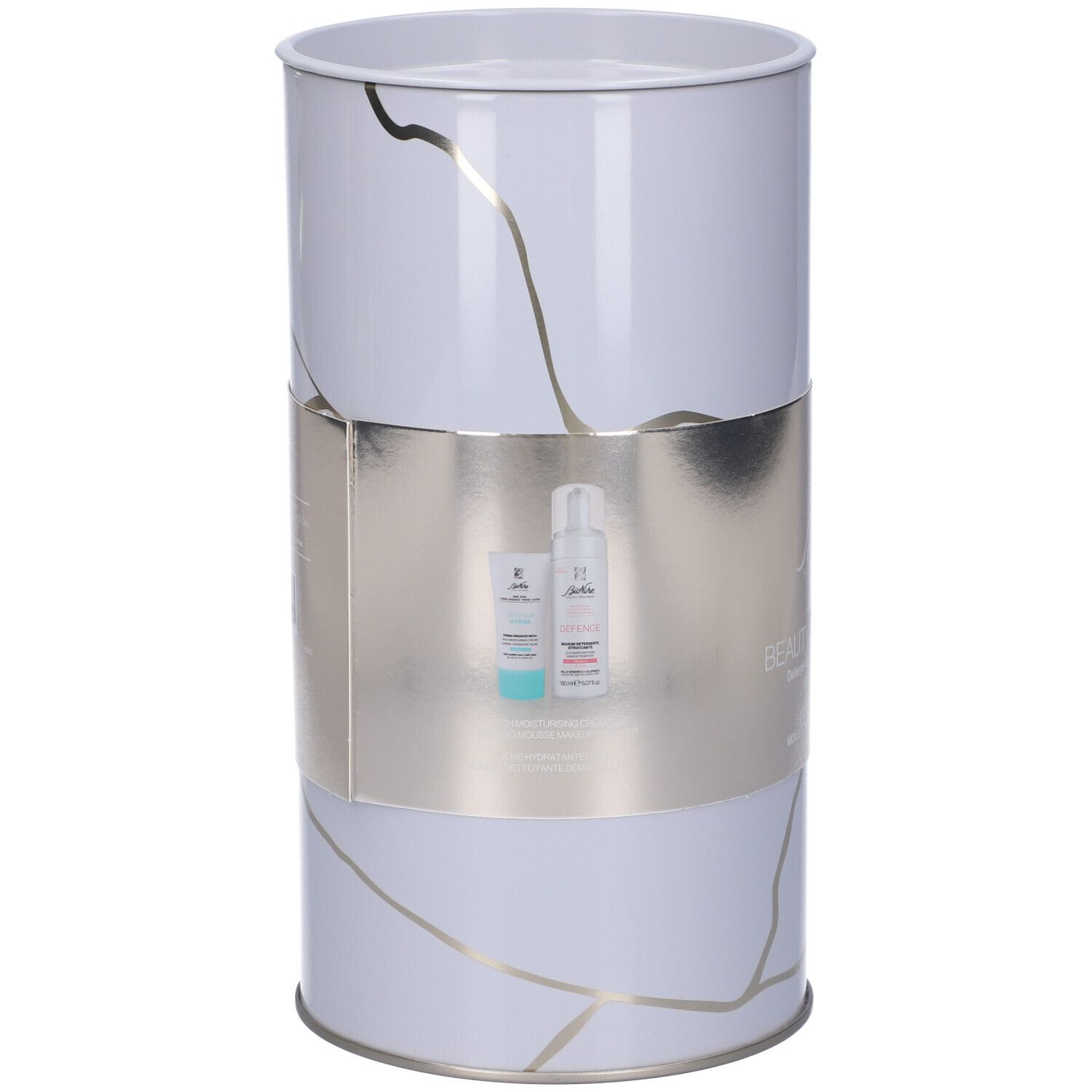Confezione regalo cilindrica con due prodotti: crema e mousse detergente. La fascia argentata riporta "Beauty Essentials".