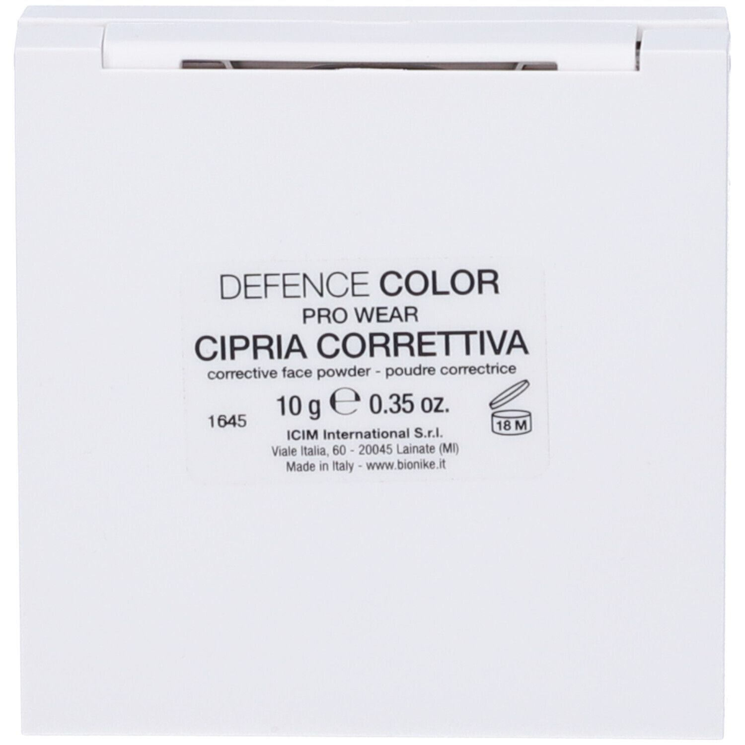 Cipria compatta bianca con etichetta. Testo: DEFENCE COLOR, CIPRIA CORRETTIVA, 10g.
