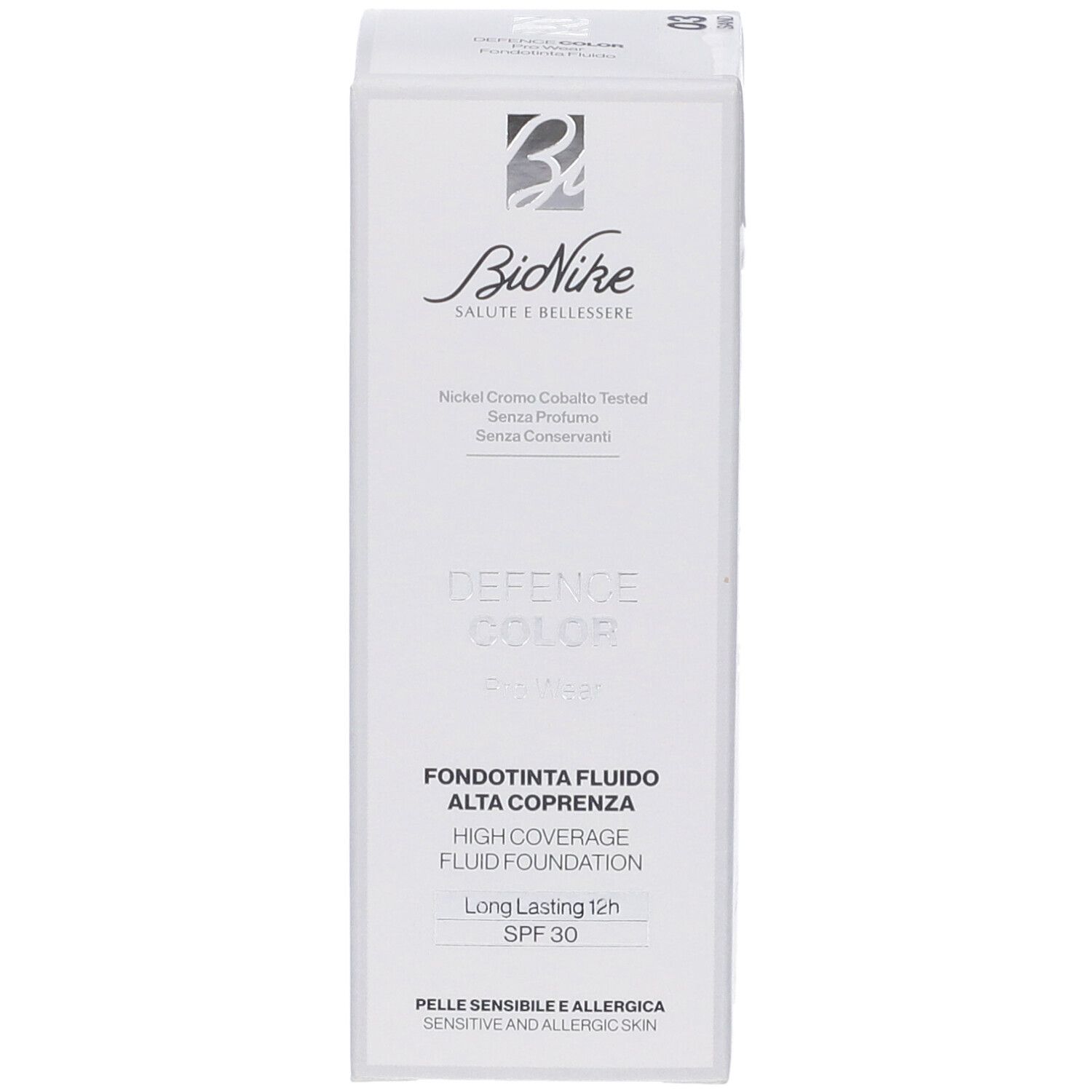 Scatola bianca con informazioni prodotto. Marchio Bionike, scritta 'Defence Color'. Testo: 'Fondotinta Fluido Alta Coprenza'.
