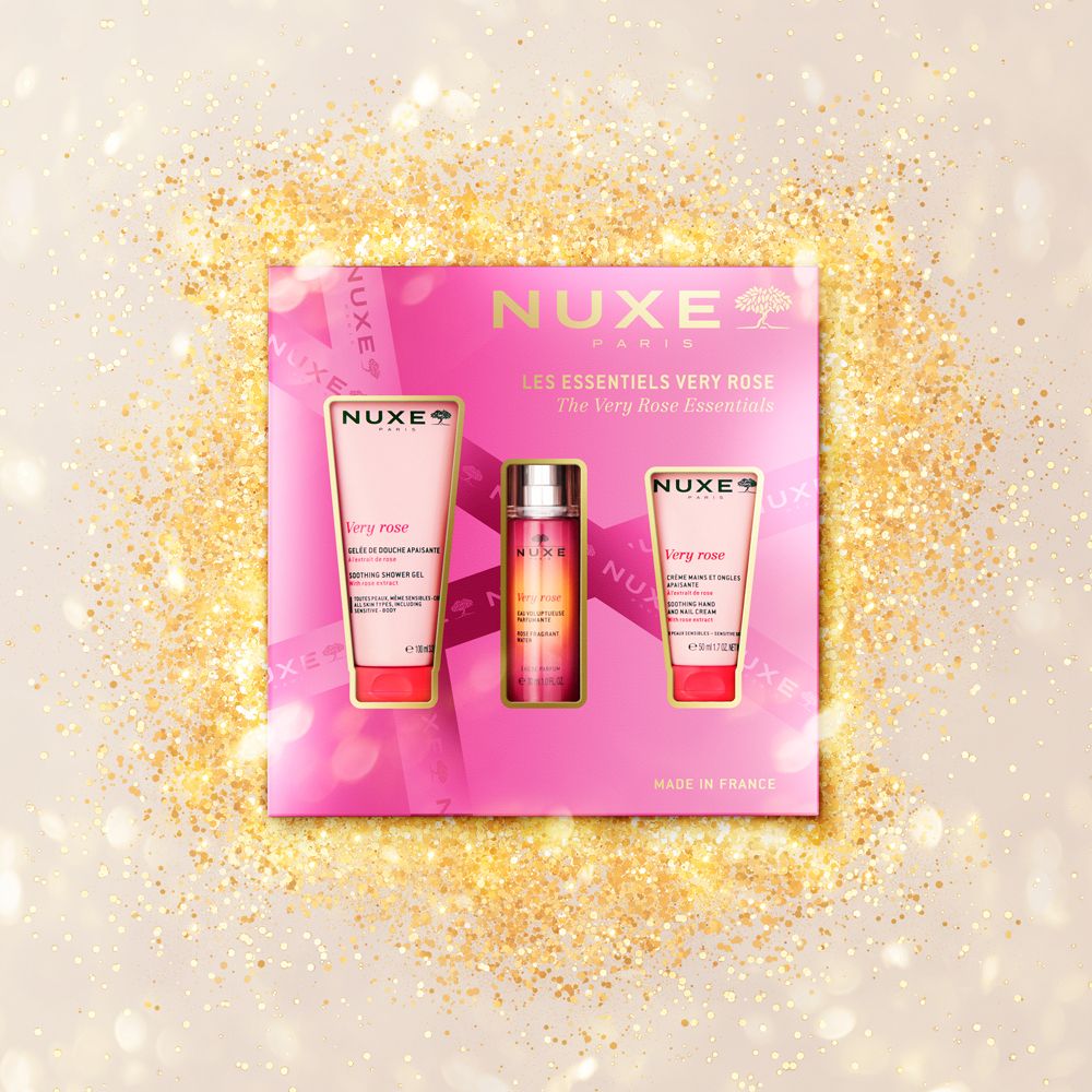 Set regalo Nuxe Very Rose su sfondo dorato. Contiene gel doccia, eau de parfum e crema mani. Confezione rosa.