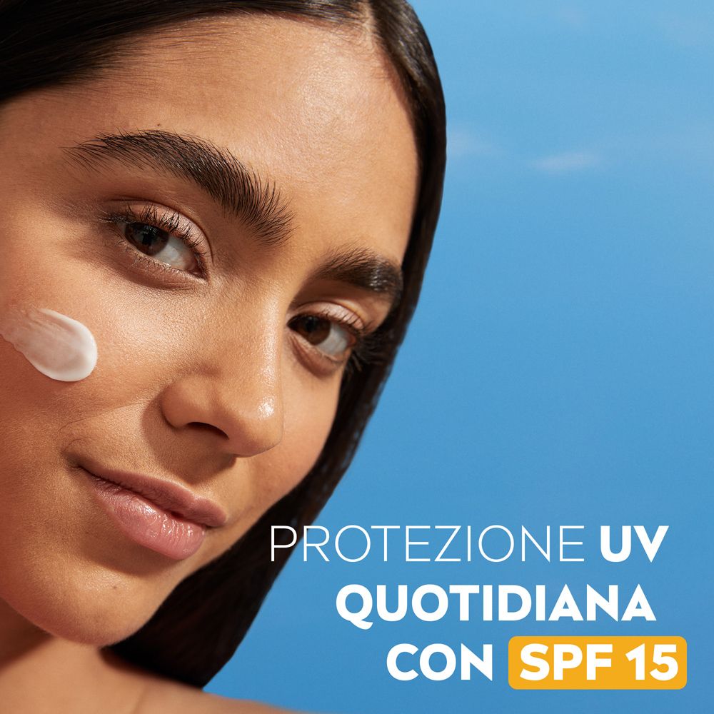 Donna con crema sulla guancia. Testo: Protezione UV quotidiana con SPF 15.