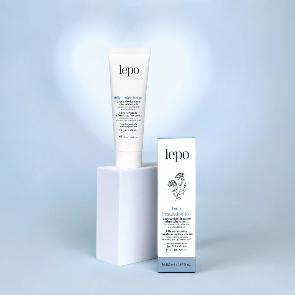 Prodotto su piedistallo bianco. Tubo e scatola. Testo: Daily Protection 50+, crema viso ultra schermante. Marchio: lepo.