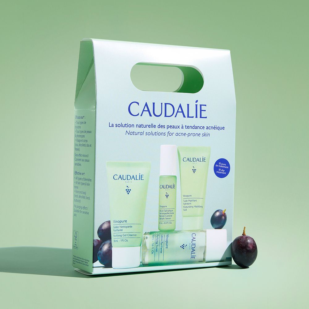 Set Caudalie con gel detergente, lozione, siero e idratante. Confezione verde con logo e testo. Uva nera.