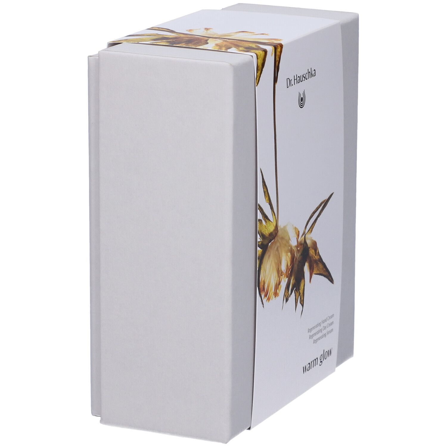 Confezione regalo bianca, design floreale. Scritta: Dr. Hauschka, warm glow. Vista laterale.