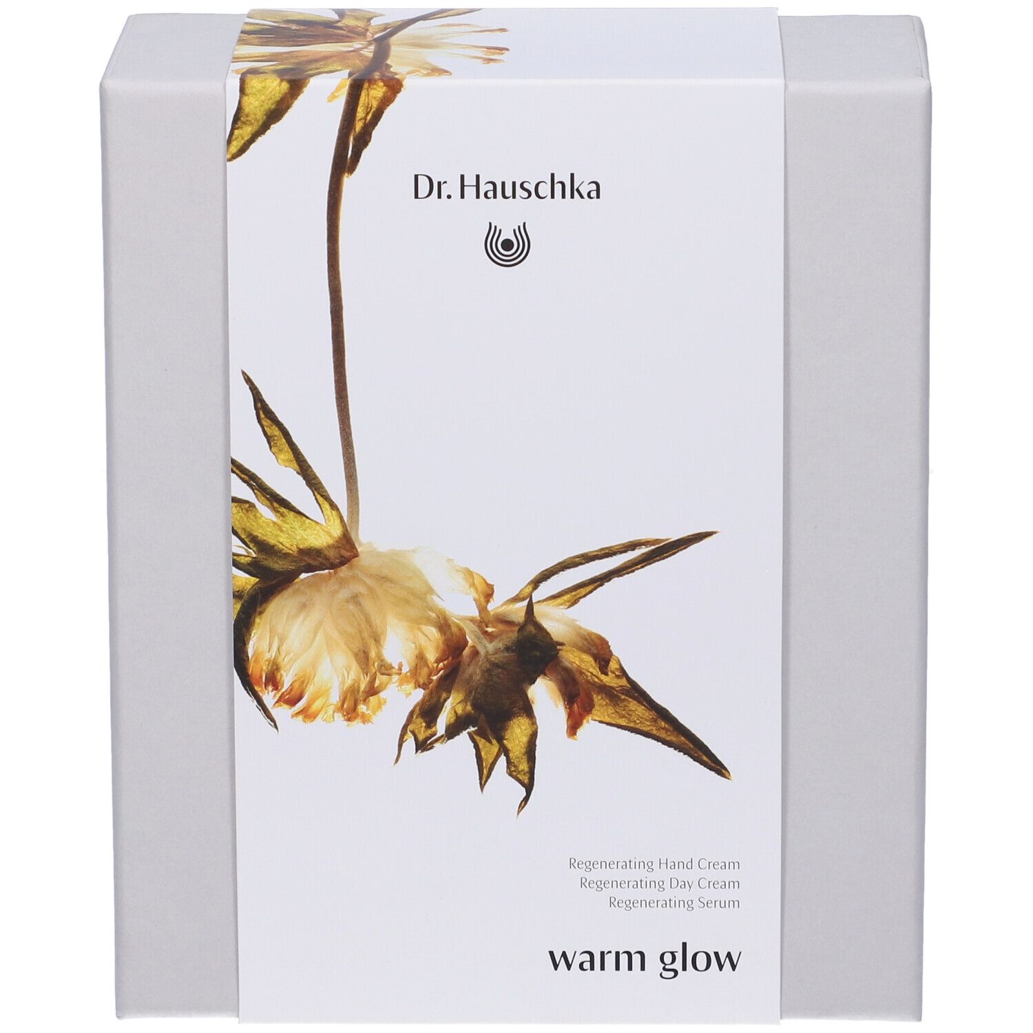 Confezione regalo con design floreale. Scritta: Dr. Hauschka, warm glow. Contiene crema mani, crema giorno, siero.