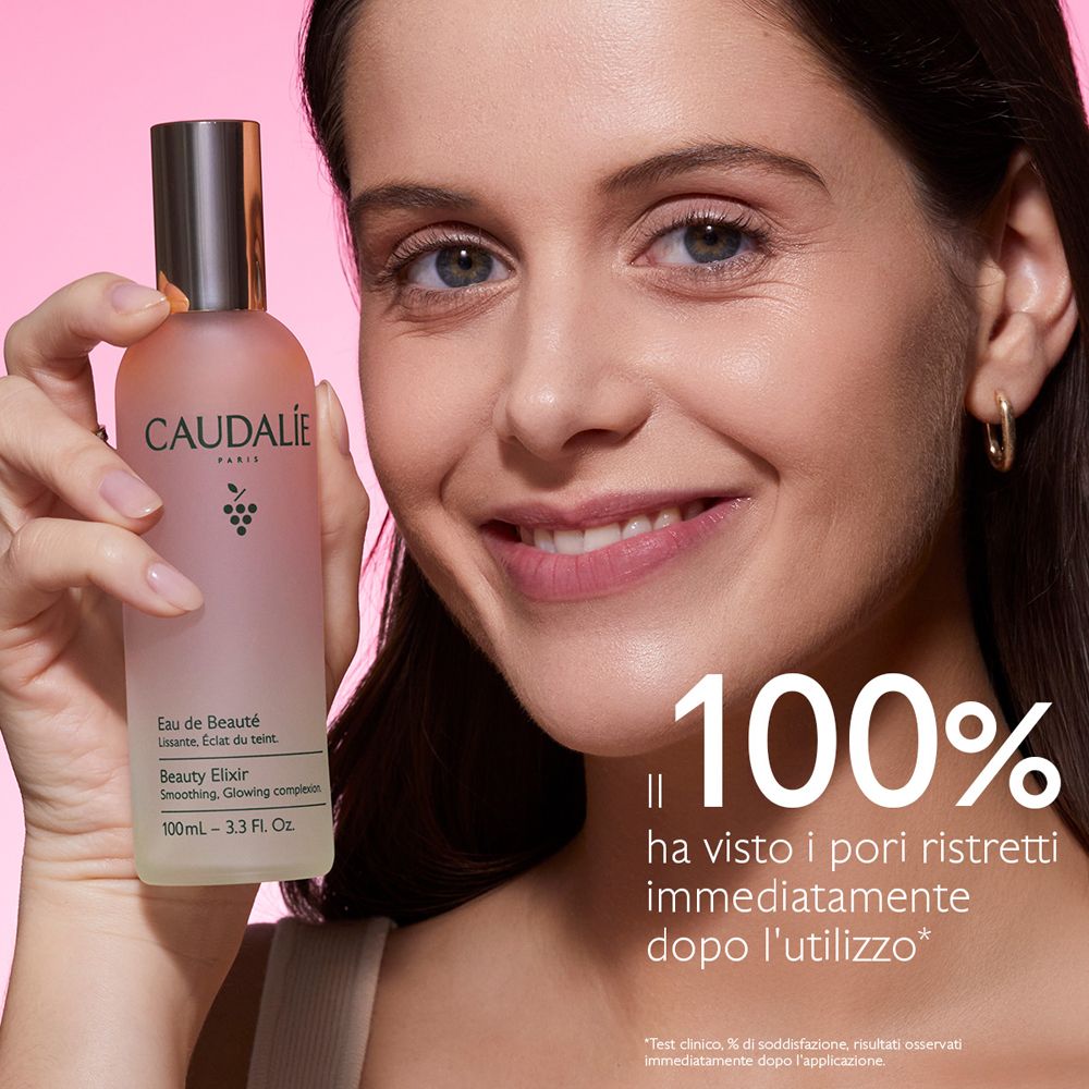 Donna tiene bottiglia Caudalie Eau de Beauté. Testo: 100% ha visto i pori ristretti immediatamente dopo l'utilizzo.
