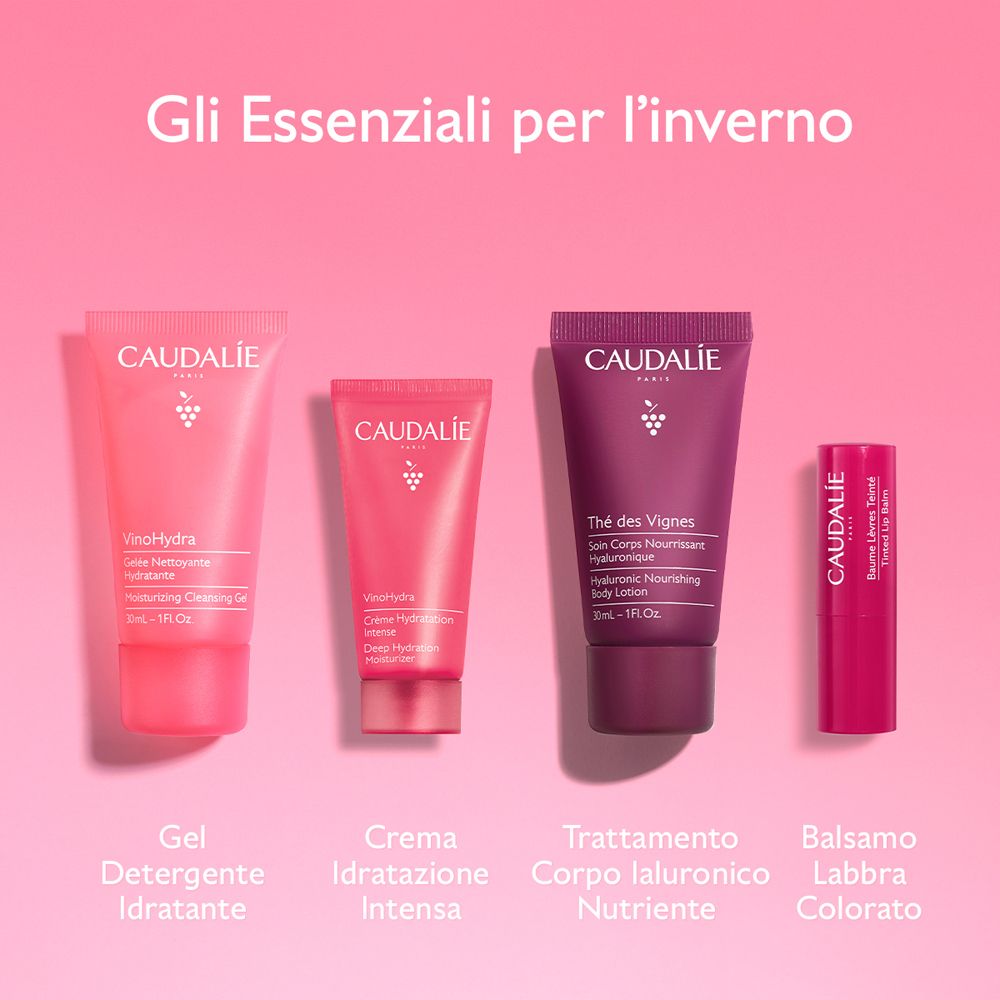 Quattro prodotti Caudalie: gel, crema, lozione, balsamo labbra. Testo in italiano. Sfondo rosa.