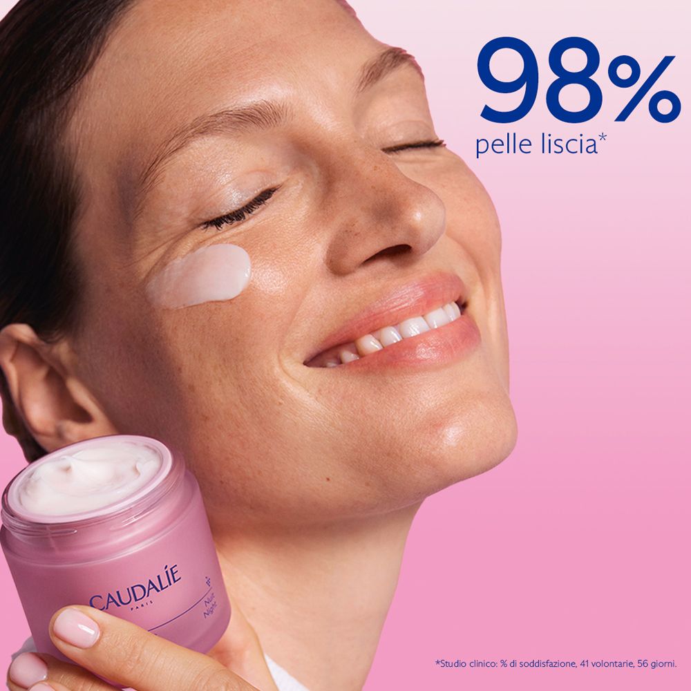 Donna con crema sulla guancia. Vasetto di crema Caudalie. Testo: 98% pelle liscia.