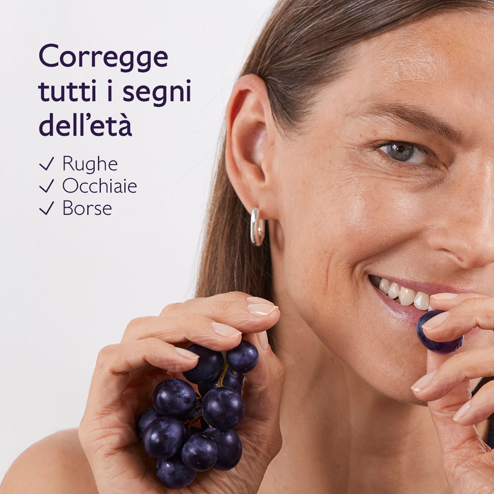 Donna con uva. Testo: Corregge tutti i segni dell'età. Rughe, occhiaie, borse.