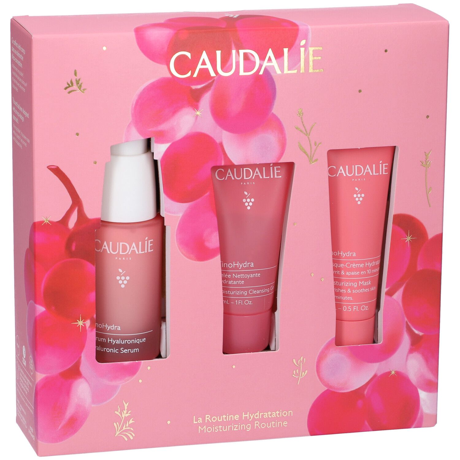 Confezione rosa Caudalie con siero, gel detergente e maschera. Sfondo con motivi di uva.