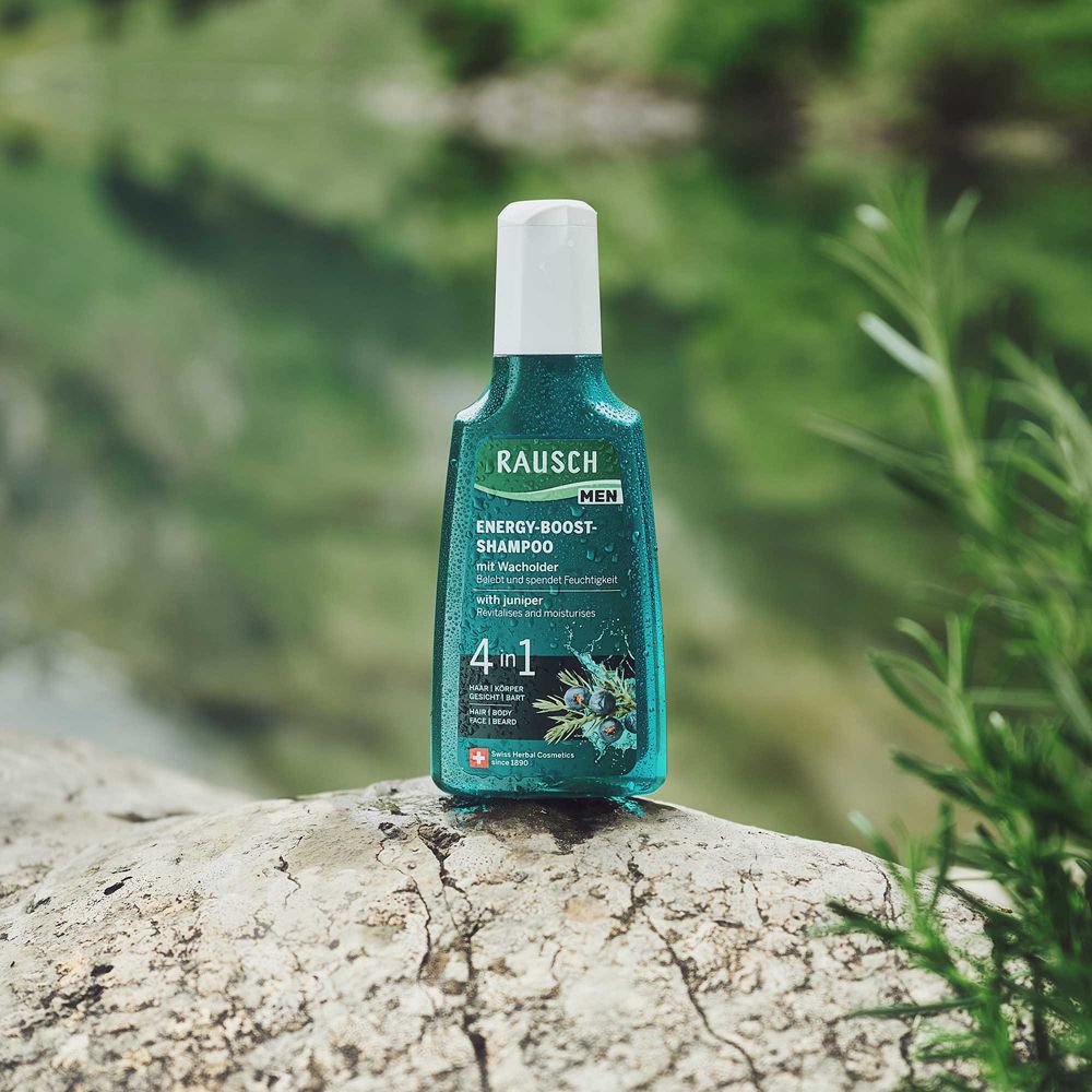 Flacone di shampoo verde su sfondo sfocato. Scritta: RAUSCH MEN, ENERGY-BOOST-SHAMPOO, 4 in 1.