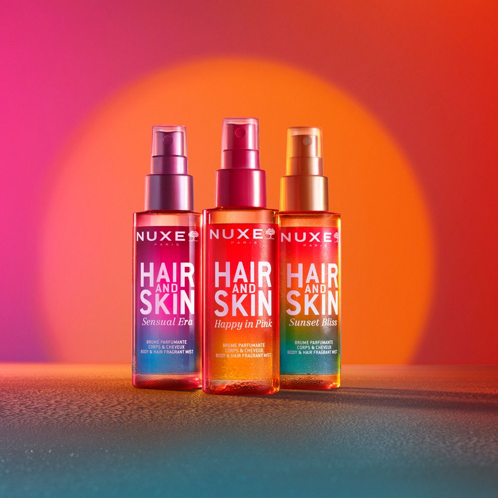Tre flaconi spray. Testo: Hair and Skin, Sensual Era, Happy in Pink, Sunset Bliss. Colori diversi.