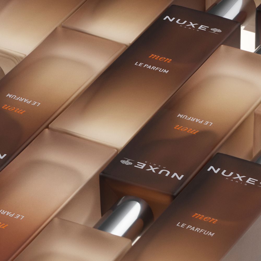 Diversi flaconi in vetro marrone con tappi argentati. Scritta: NUXE Paris, men, LE PARFUM.