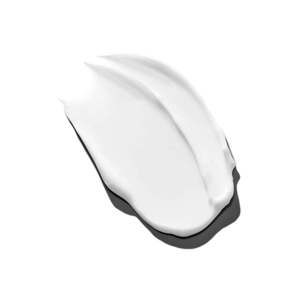 Macchia di crema bianca su sfondo bianco. La crema ha una consistenza liscia.