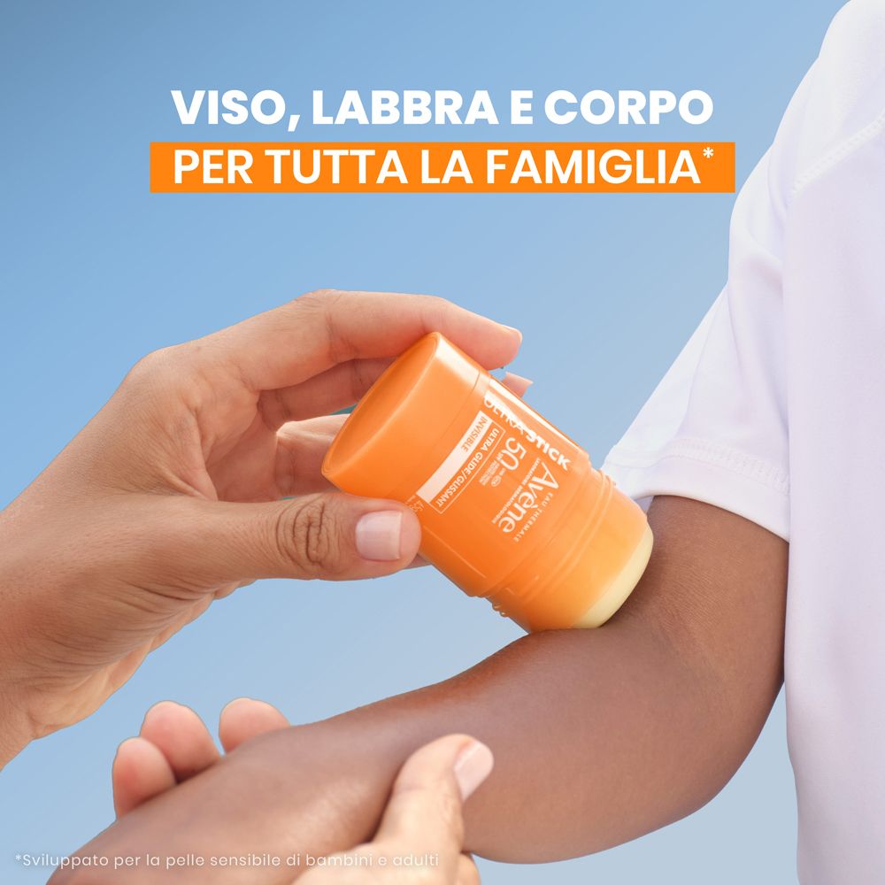 Persona applica la protezione solare sul braccio. Testo: Viso, Labbra e Corpo, Per Tutta La Famiglia.