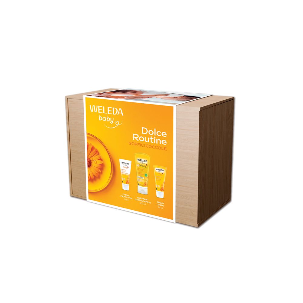 Scatola di legno con stampa. Scritte: Weleda Baby, Dolce Routine. Contiene tre prodotti per l'infanzia.