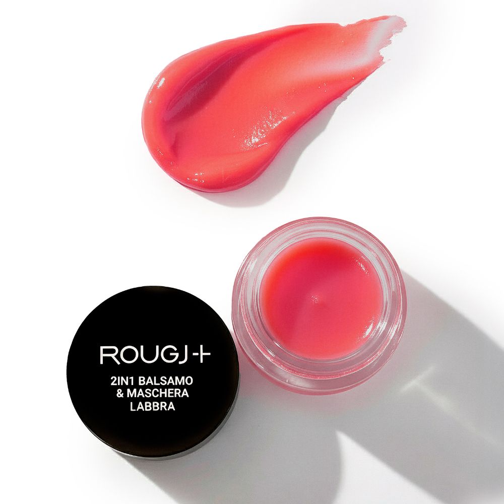 Vasetto rotondo di balsamo rosso, accanto una macchia di balsamo. Coperchio nero con scritta.